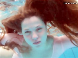 ginger-haired Simonna demonstrating her assets underwater